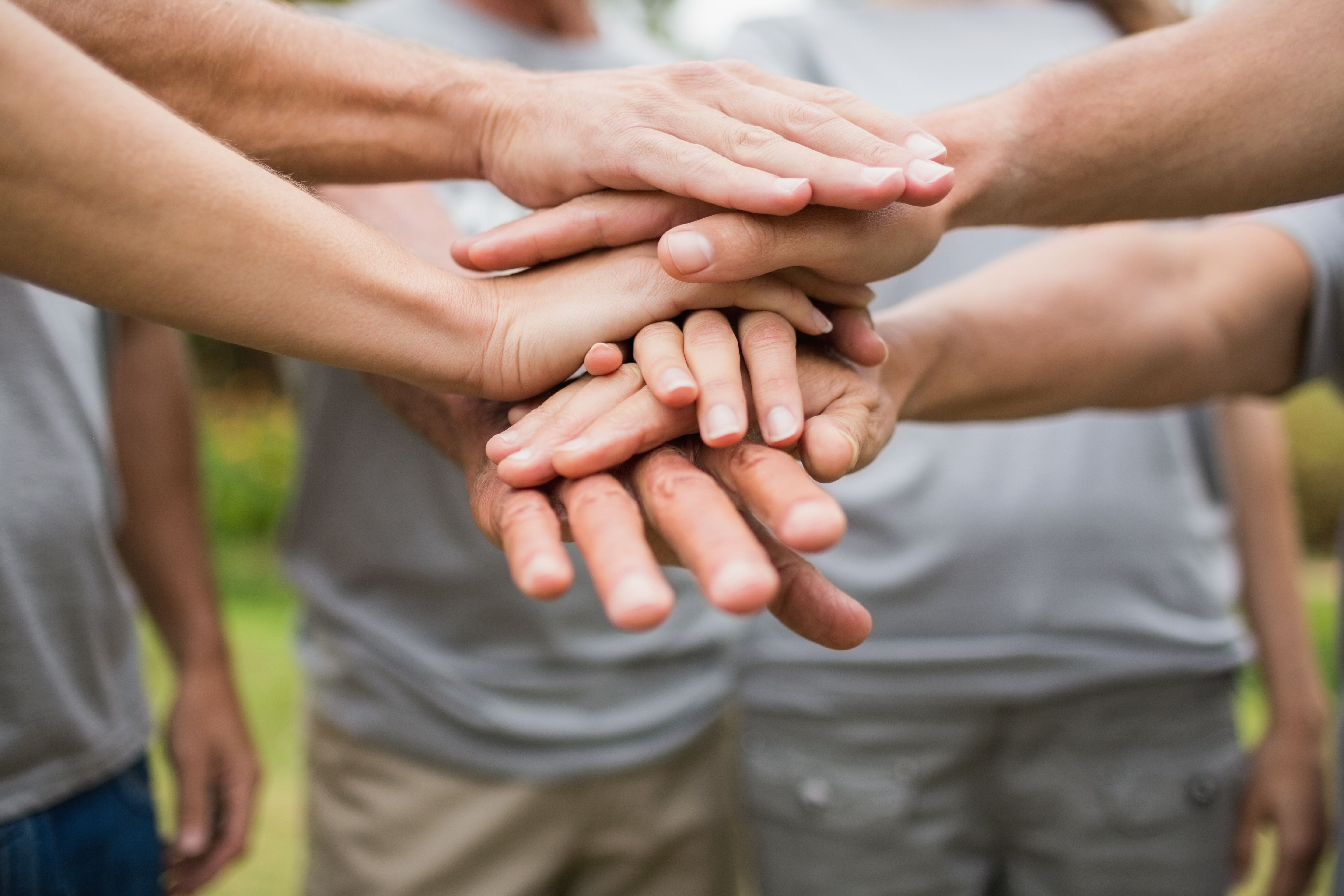 People placing their hands together in a gesture of shared support
